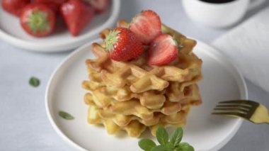  Beyaz bir masada çilekli ev yapımı waffle 'lar.