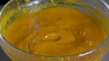 Turuncu balkabağı kabağındaki kabak çorbası kaşıkla karıştırılır.