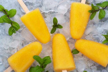 Lezzetli Ev Yapımı Buzlu Dondurmalar ve Portakal Suyu Buzlu Meyveli Lolipoplar Sticks Ice Cube Top View Düz Yatakta. Turuncu Dondurma