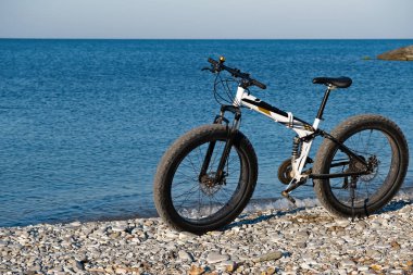 Plaj bisikletine park etmiş, devamını bekliyor.