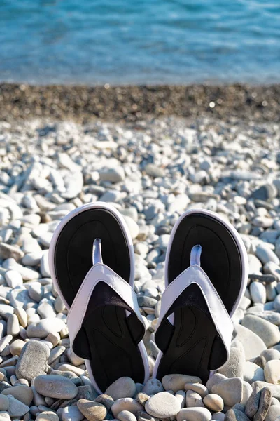 Black Flip Flops Pebble Beach Turquoise Sea Summertime Vacation Concept — Stock Photo, Image