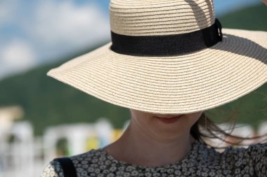 Yaz tatilinde kumsalda hasır şapka takan bir kadın. Tatil kavramı