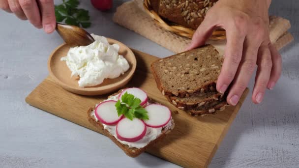 Žena připravuje sendviče a pomazánky měkký sýr na chleba, 4k video — Stock video