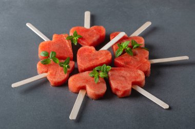 Gri masadaki çubuklarda karpuz dilimleri