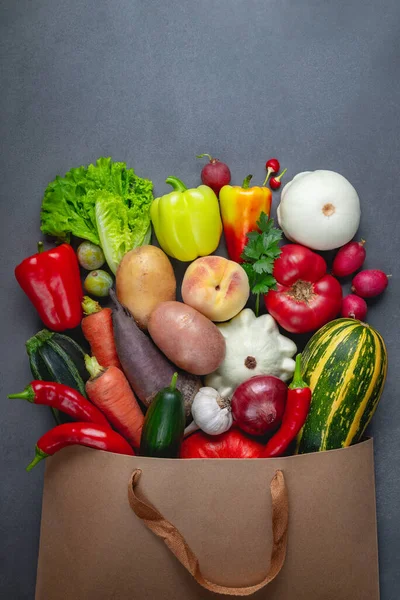 Здорова вегетаріанська їжа в паперовій сумці овочі та фрукти на сірому — стокове фото