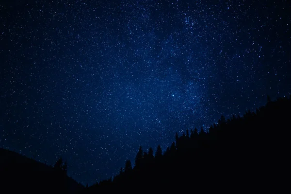 Nachthimmel mit Sternen, Satelliten. Milchstraße, die in Langzeitbelichtung vorbeizieht. Schöne Panoramasicht mit Fels, Berg. Natur, Universum, Galaxie, Astronomiekonzept. — Stockfoto