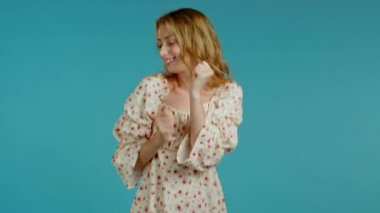 Mavi stüdyo arka planında enerjik ve aktif dans eden güzel bir kadın. Şirin kızlar portresi. Parti, mutluluk, özgürlük, gençlik kavramı.