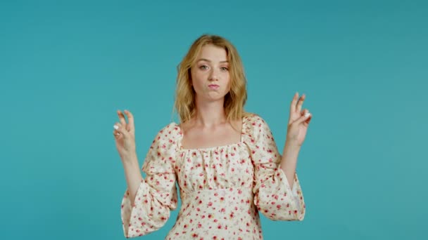 Pretty girl showing with hands and two fingers like quotes gesture, bend fingers isolated over blue background. Very funny, irony and sarcasm concept. — Stock Video