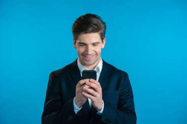 Yakışıklı bir iş adamı cep telefonundan mutlu bir haber alır. Adam şaşkınlık ve sevinçle kendinden geçmiş. Kazandı ve sevindi. Teknoloji, başarı, zafer, mutluluk kavramı.
