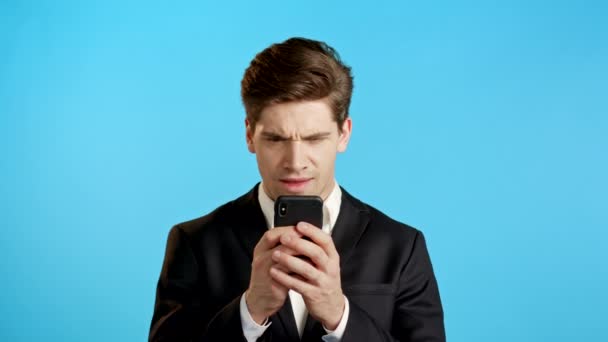 Az üzletember rossz bejelentést kap a mobilján. A fickó boldogtalan, csalódott. Technológiai koncepció. — Stock videók