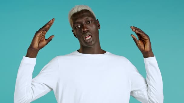 African american bored man showing bla-bla-bla gesture with hands and rolling eyes isolated on blue background. Empty promises, blah concept. Lier — Stock Video