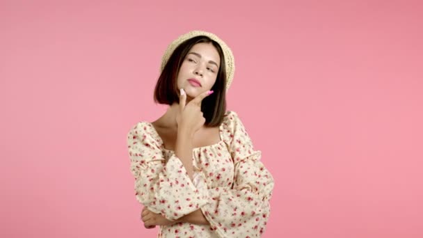 Σκεπτόμενη γυναίκα κοιτάζει πάνω και γύρω σε ροζ φόντο. Χαρούμενες εκφράσεις προσώπου. Όμορφο μοντέλο με ελκυστική εμφάνιση — Αρχείο Βίντεο