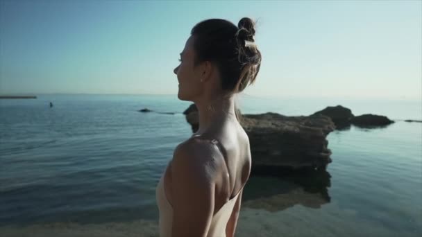Krásná žena kráčí po moři po písčité pláži. Dívka na tropické dovolené s kameny. Luxusní cíl. Cestování, příroda, letní koncept. Zpomalený pohyb. — Stock video