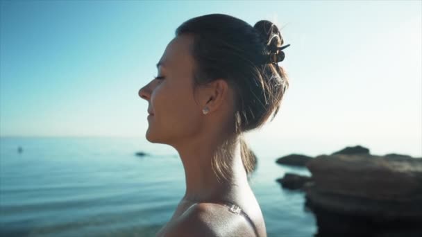 Mujer joven caminando a lo largo del mar en la playa rocosa. Una chica de vacaciones tropicales. Destino de lujo. Viajes, naturaleza, concepto de verano. Movimiento lento. — Vídeos de Stock