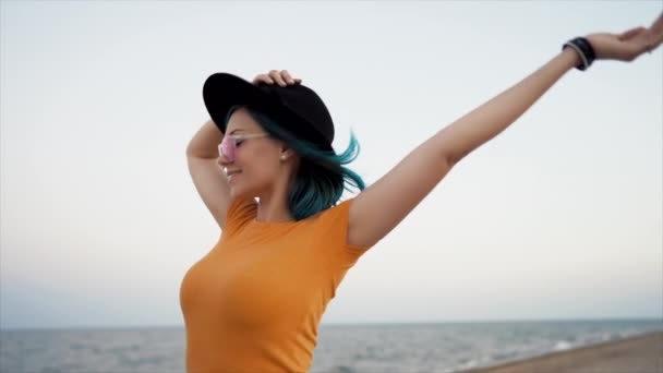 Femme inhabituelle insouciante avec des cheveux teints en bleu dansant, tournant autour sur fond de mer. Fémininité, vacances, vitalité, mode de vie sain. Hipster fille en chapeau avoir du plaisir, rire. — Video