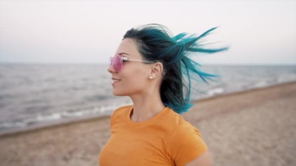 Mulher bonita com cabelos azuis tingidos corre perto do mar ou do oceano, desfrutando de liberdade durante as férias de verão, viagens. Menina feliz bonita lá fora. Movimento lento. — Vídeo de Stock