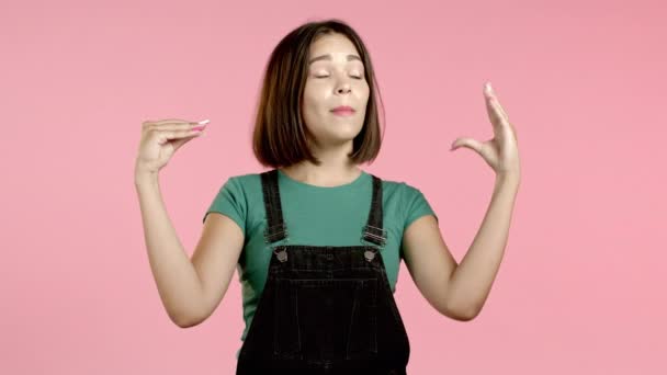 Cute girl showing bla-bla-bla gesture with hands and rolling eyes isolated on pink background. Empty promises, blah concept. Lier. — Stock Video