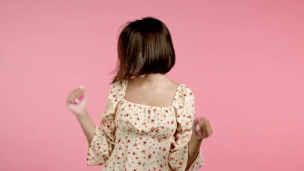 Bella donna che balla attivamente in maschera su sfondo rosa studio. Ritratto ragazze carine. Festa, felicità, libertà, concetto di gioventù. Protezione con respiratore contro il focolaio di COVID-19. — Video Stock
