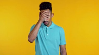 Afrikalı bir adamın facepalm hareketi yaparken portresi, hayır, unuttum. Mutsuz siyah adam üzüntü, pişmanlık, drama, başarısızlık hissediyor. Sarı duvarda izole edilmiş.