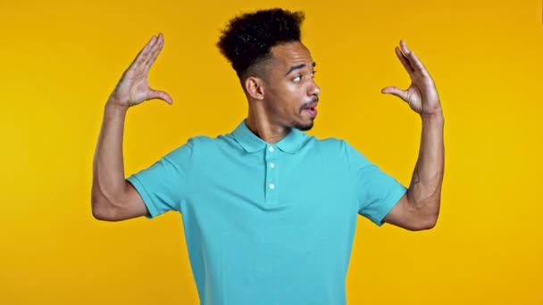 African american bored man showing bla-bla-bla gesture with hands and rolling eyes isolated on yellow background. Empty promises, blah concept. Lier — Stock Video