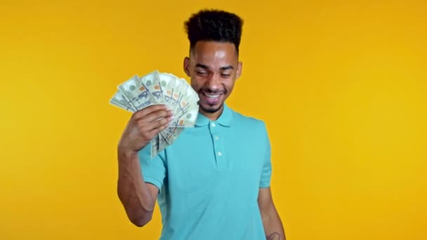 Incroyable heureux homme africain excité avec de l'argent billets en dollars américains sur le mur jaune studio. Symbole de succès, gain, victoire. — Video