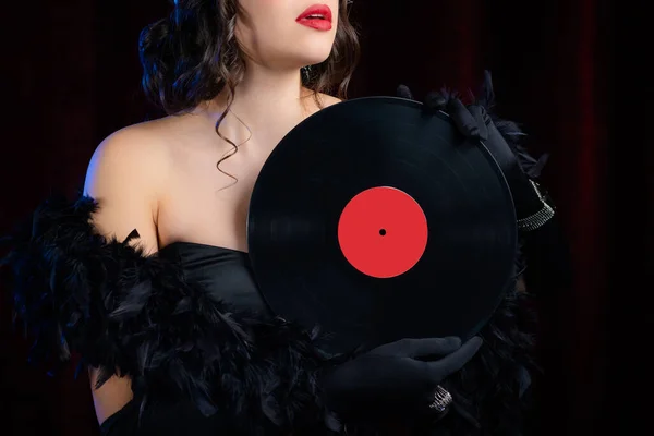 Unrecognizable woman dressed in style of art deco holding vinyl record on dark background. Roaring twenties, Flappers, retro, party, fashion concept. New Year or Christmas celebration. — Stock Photo, Image