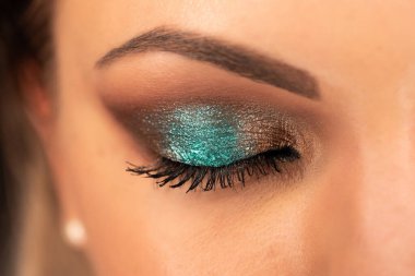 Kadın yüzüne harika bir makyajla yakın çekim, parlak gölgeli gözler. Sanat, güzellik endüstrisi, kozmetik konsepti.