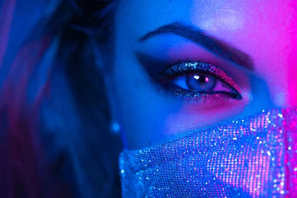 Close up of face in glitter protective mask, amazing make-up. Eye under neon light. Female with shining shadows and false lashes. Nightlife, night club, pandemic, covid-19 concept. — Stock Photo, Image