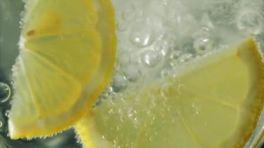 Maden suyu, limon dilimli cam bir şişeye dökülür. Süper kabarcıklar ve gazlar. 4k