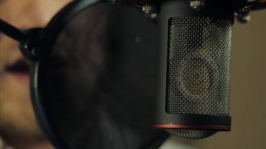 Adamın biri kayıt stüdyosunda rap okuyor.