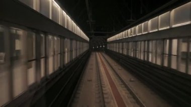 Hareket halindeki trenin arka penceresinden metro tünelinin görüntüsü. Hızlı yeraltı treni modern metro istasyonundan ayrılıyor. Barselona 'daki bir yeraltı treninin rotasını takip eden uzun görüntüleri.