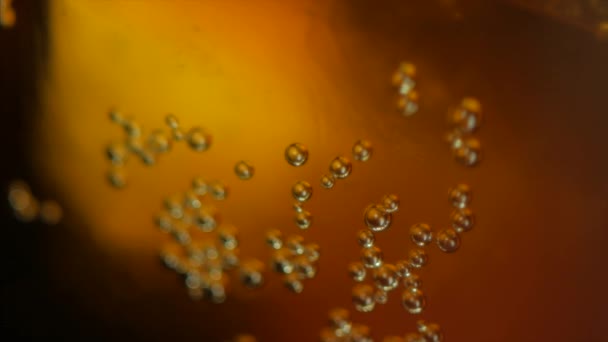 Fizzy beber bolhas de cola contra laranja escura. 4k — Vídeo de Stock