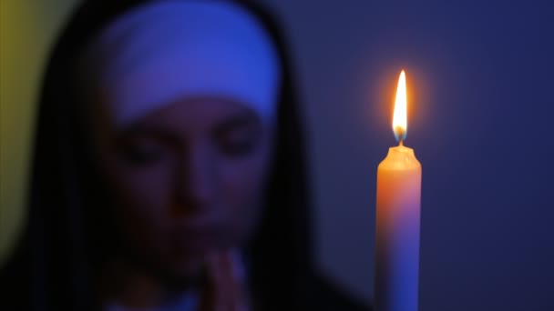 Una monja rezando por la noche. encender velas. Mujer vestida de monjas. HD — Vídeo de stock