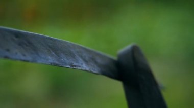 Çiftçi tırpanı taşla keskinleştiriyor. Çim biçmeye başlamak için tırpanı keskinleştiren adam. Bir çiftçinin tırpanı törpülediği ağır çekim görüntülerini dosyalama makinesinin ortasında keskinleştirirken çek.