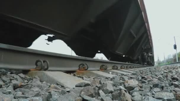 Vista dal basso sul treno ferroviario e merci in movimento. Primo piano delle ruote. — Video Stock