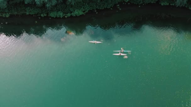 Nádherné letecké záběry mužů plavajících v kajaku na modré říční vodě. Pohled na drony. Po vysoko nad skupinou kajakářů v kánoích. Sportovní aktivita, koncept dobrodružství. — Stock video