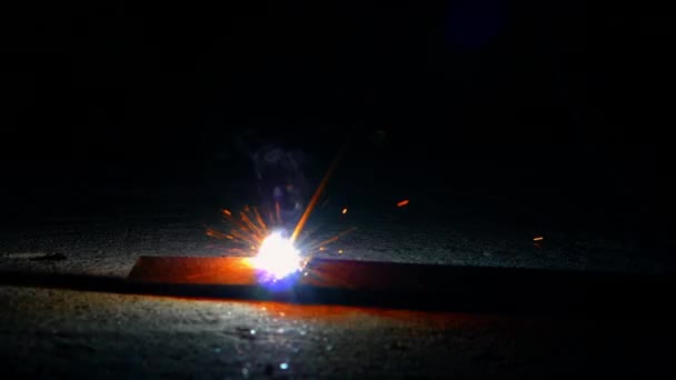 Travailleurs de meulage et de soudage dans une usine. Soudage sur une installation industrielle. Au ralenti. Flashs et beaucoup d'étincelles provenant des travaux de soudage sur le chantier dans l'obscurité — Video