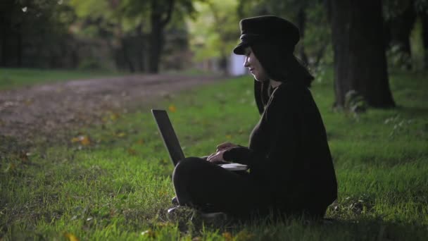 Κορίτσι που χρησιμοποιεί φορητό υπολογιστή έξω στο πάρκο. Αργή κίνηση — Αρχείο Βίντεο