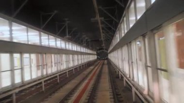 Hareket halindeki bir trenin arka camından bir metro tünelinin görüntüsü. Yeraltı treni modern metro istasyonuna varıyor. Barcelona 'daki bir yeraltı treninin rotasını takip eden uzun görüntüleri. 4k