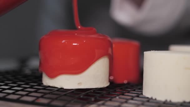 The red icing on the cakes. Modern French mousse desserts with mirror glaze. Footage for a menu or a confectionery catalog. Slow motion — Stock Video
