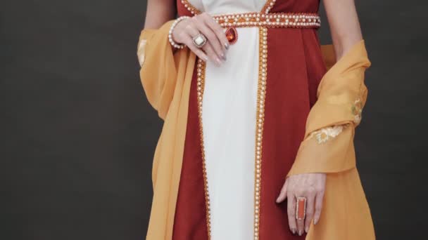 Piękna kobieta stojąca w starej historycznej XVIII-wiecznej sukience królewskiej na czarnym tle w studio. Spójrz na Marię Antoninę na balu. Szczegóły kostiumu, biżuterii skarbowej. Zwolniony ruch. — Wideo stockowe