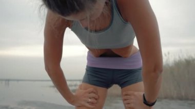 Yoga yapan kadın karın ağrısı Uddiyana orkestrası, yoga yapan kadın ağır mide ağrısı çekiyor, kumsalda nefes alıp verişini yavaşlatıyor ve meditasyon yapıyor. Yavaş çekim.