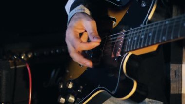 Konserde elektro gitar çalan adam. Gitaristin karanlık odada elektro gitar çalışına yakından bakın. Yavaş çekim