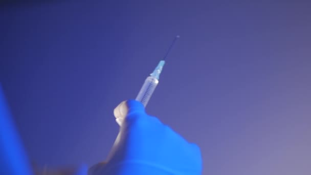 Asistenta medicală sau medicul din mănuşi filmează seringa înainte de injectarea medicamentului, pentru a colecta şi elibera aerul din seringă. . — Videoclip de stoc