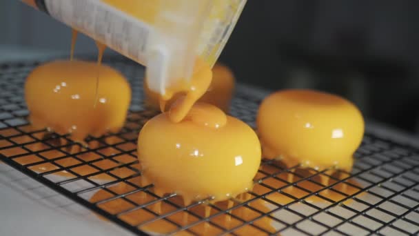 Detailní Slow Motion Shot of a Colful Yellow Mirror Glaze being Poured on the Frosted Desserts. Zpomalený pohyb. — Stock video