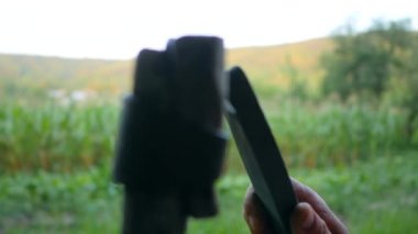 Çiftçi tırpanı taşla keskinleştiriyor. Çim biçmeye başlamak için tırpanı keskinleştiren adam. Bir çiftçinin tırpanı törpülediği ağır çekim görüntülerini dosyalama makinesinin ortasında keskinleştirirken çek.