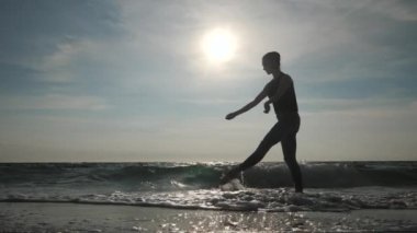 Sıradan tarzda giyinmiş genç bir kadının silueti. Kumsalda bale yapan kot ve siyah bluz. Çekici balerin, sonbaharda kumlu kıyı şeridinde esneme çalışması yapar. Ağır çekim. Film tonlu görüntüler