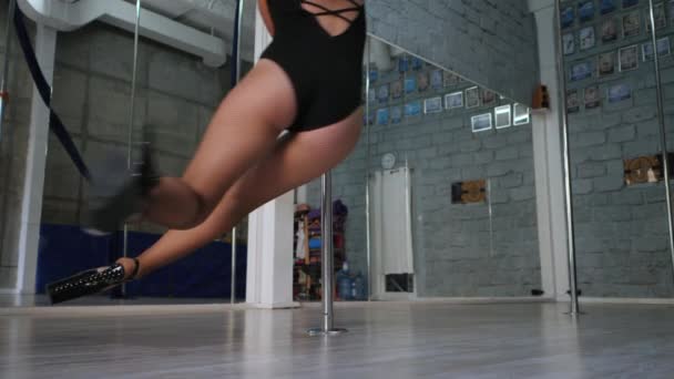 Ung sexig smal kvinna med långt hår pol dans i grå inredning.Beautiful, attraktiv flicka utför pole dance. Damen med bra figur dansar på pylon. Långsamma rörelser. — Stockvideo