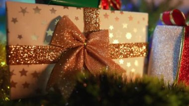 Noel arkaplanının hediye kutusuyla yakın çekimi. Altın kurdele, bayram konsepti..