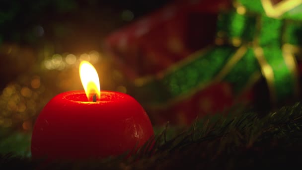 तरीही जीवन पारंपारिक ख्रिसमस भेटवस्तू, स्प्रूस शाखा आणि भेटवस्तू विरुद्ध जळत्या मेणबत्तीचे बंद. आश्चर्यकारक गोषवारा पार्श्वभूमी. हिवाळी उत्सव. शुभेच्छा सुट्टी संकल्पना . — स्टॉक व्हिडिओ